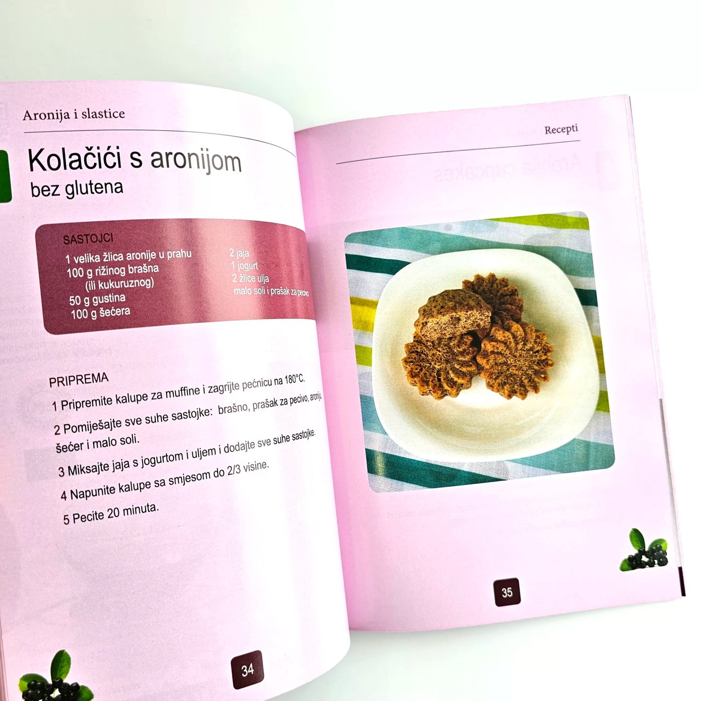 Aronija i Slastice (Aronia Desserts) Open cookbook showing a recipe for cookies with aronia berries on a white background