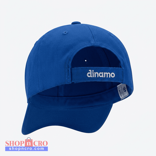 A royal blue baseball cap shown from the back, featuring a curved brim and a hook-and-loop strap closure with the brand name 'dinamo' embroidered in white. A small sewn-in size tag is visible on the side. Baseball Cap Dinamo Zagreb in Blue shopncro