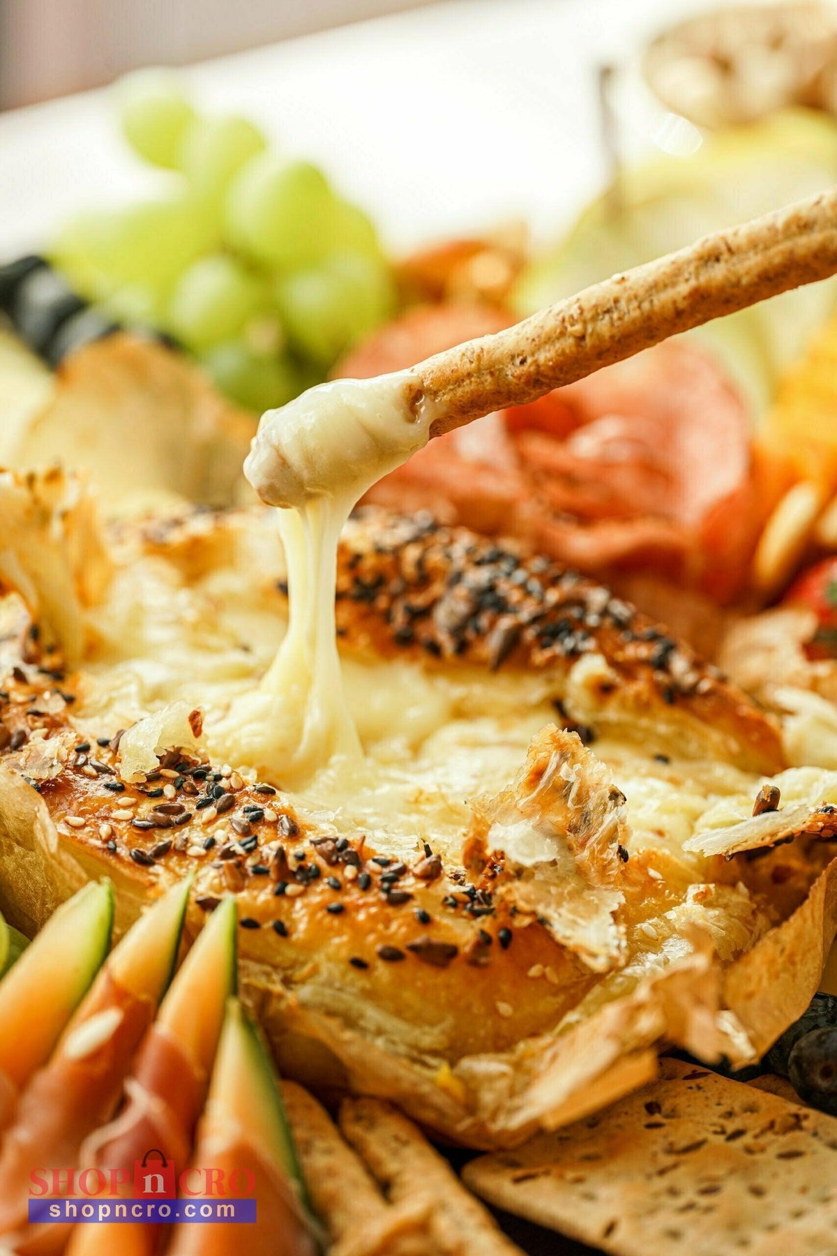 Creative Cooking – Cheese (Sir) Cheesy bread with melted cheese oozing out, surrounded by fruits and meats on a plate.