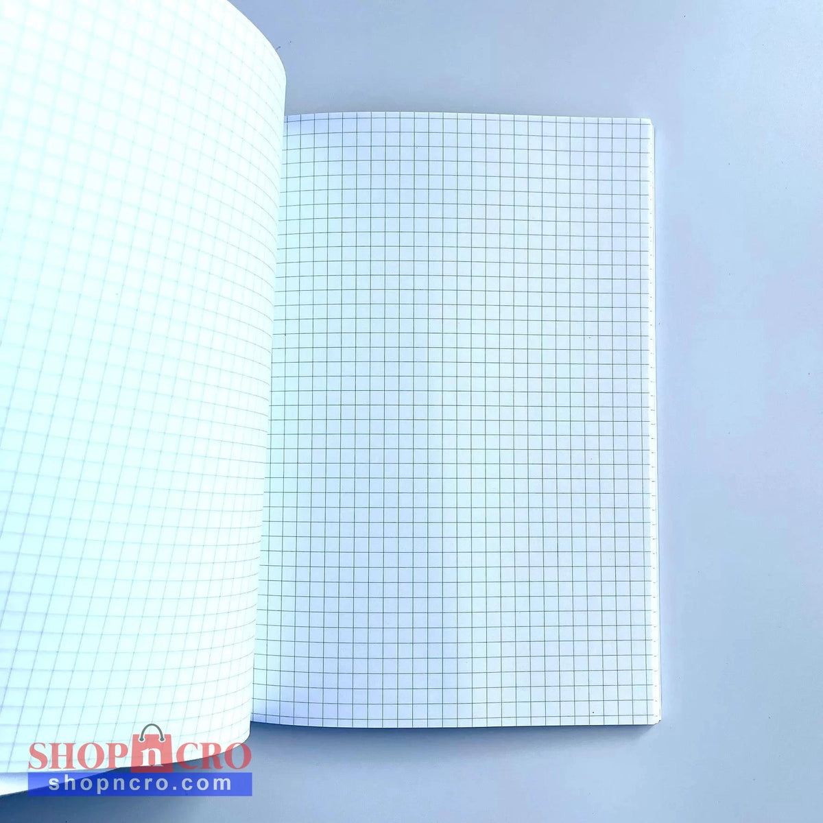 GNK Dinamo A5 Writing Book / Note Pad Open notebook with grid paper on a light blue background
