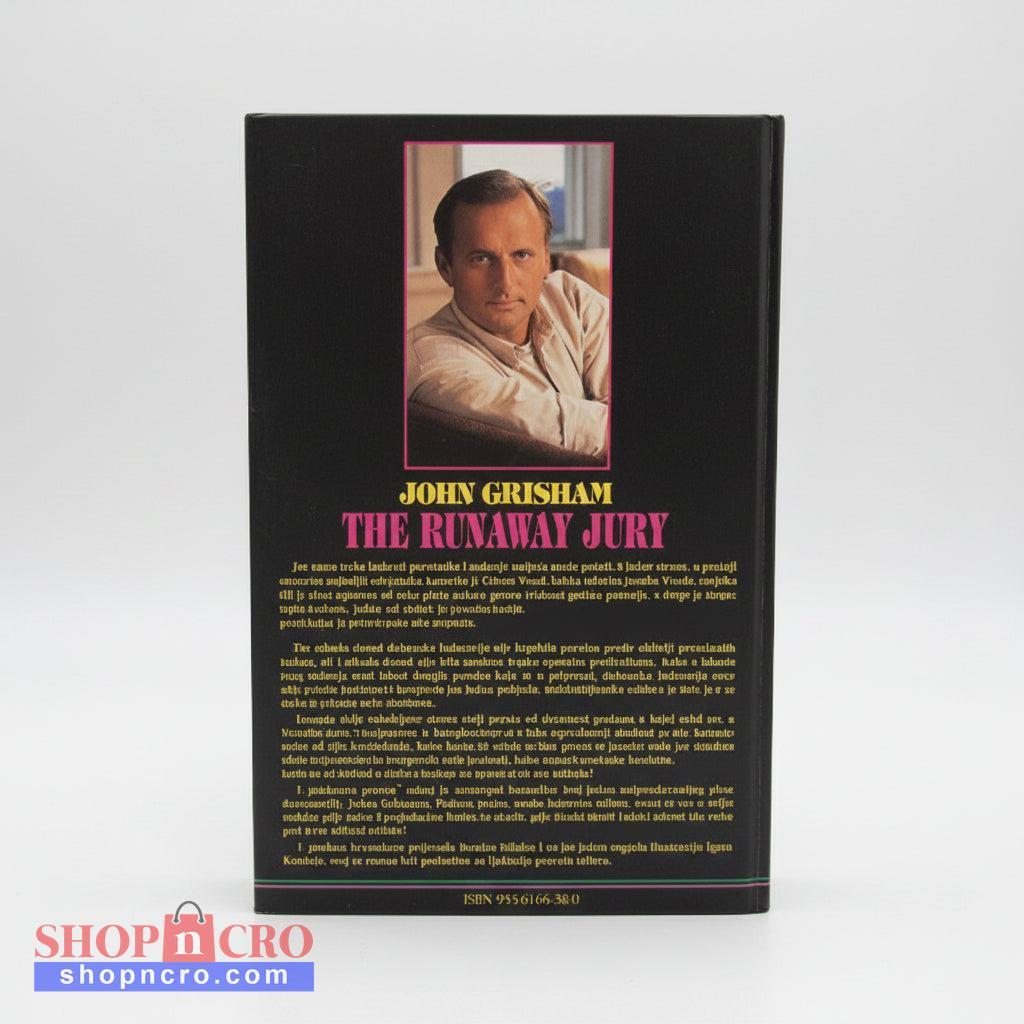 John Grisham - Odmetnuta Porota Book titled 'The Runaway Jury' by John Grisham on a wooden surface with a white wall background.