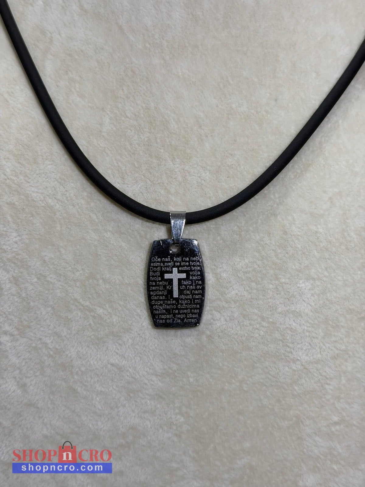 Oče Naš Necklace Black pendant with cross on a black cord against a light gray background
