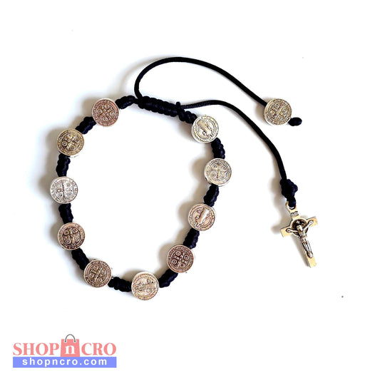 Saint Benedict Adjustable Bracelet with Cross (Black) Black cord bracelet with metal coins and a cross on a white background