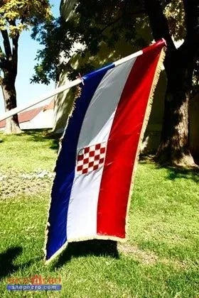 Silk Flag Prvo Bijelo Polje 200x100 Croatian flag waving in the wind on a grassy area with trees in the background