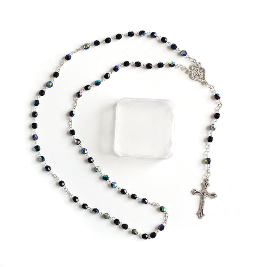 Black Crystal Catholic Rosary with Silver Crucifix and Alpha Omega Centerpiece Rosary with black beads and a cross on a white background