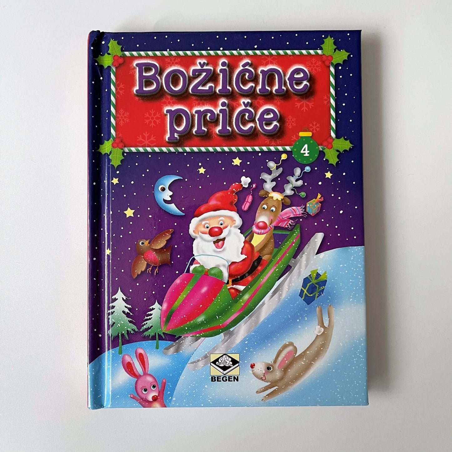 Božićne Priče Children's book cover with Santa Claus and reindeer on a purple background