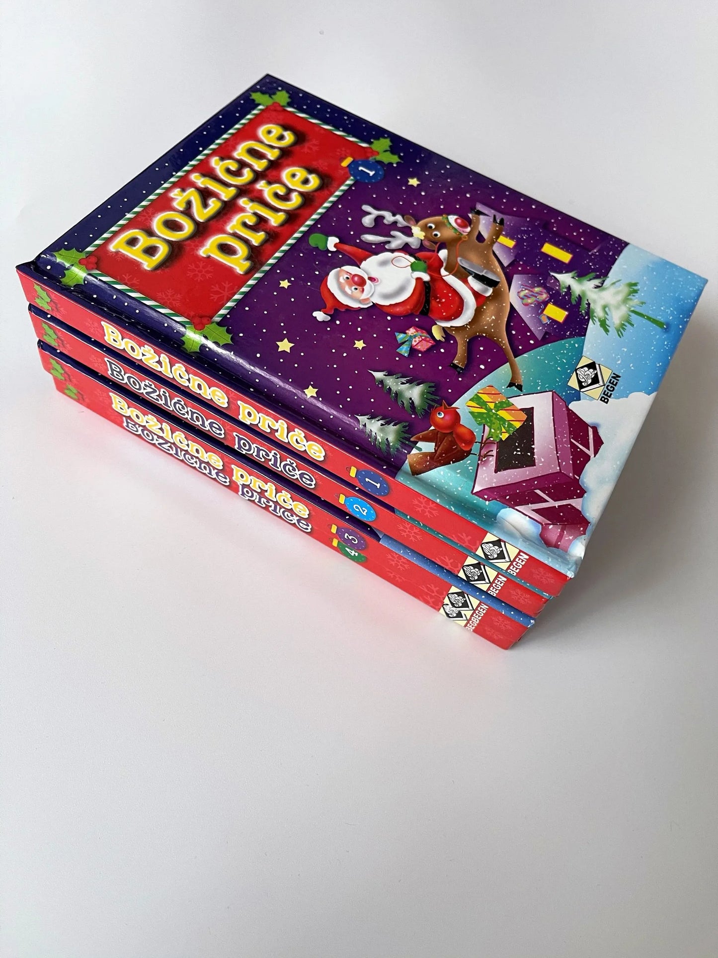 Božićne Priče Stack of 'Bozene Prize' books with festive design on a white background