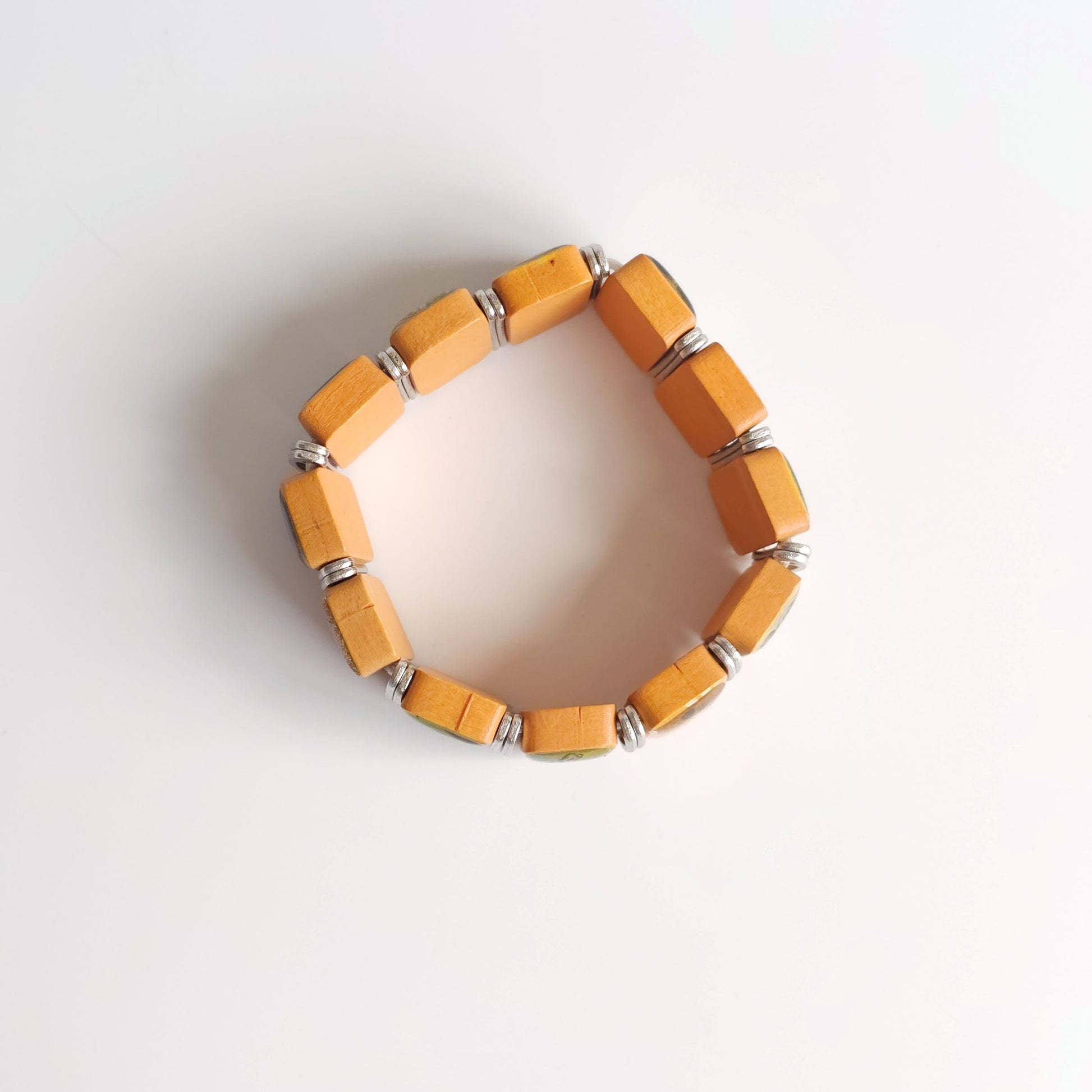 Bracelet Međugorje in Oak (Flat Spacer) Yellow beaded bracelet on a light gray background