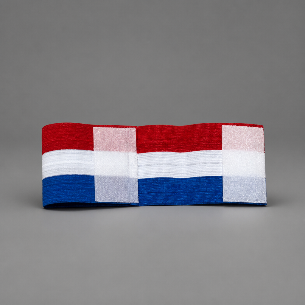 A fabric headband featuring a Dutch flag pattern with red, white, and blue horizontal stripes, photographed on a neutral gray background. Croatia Captain Armband