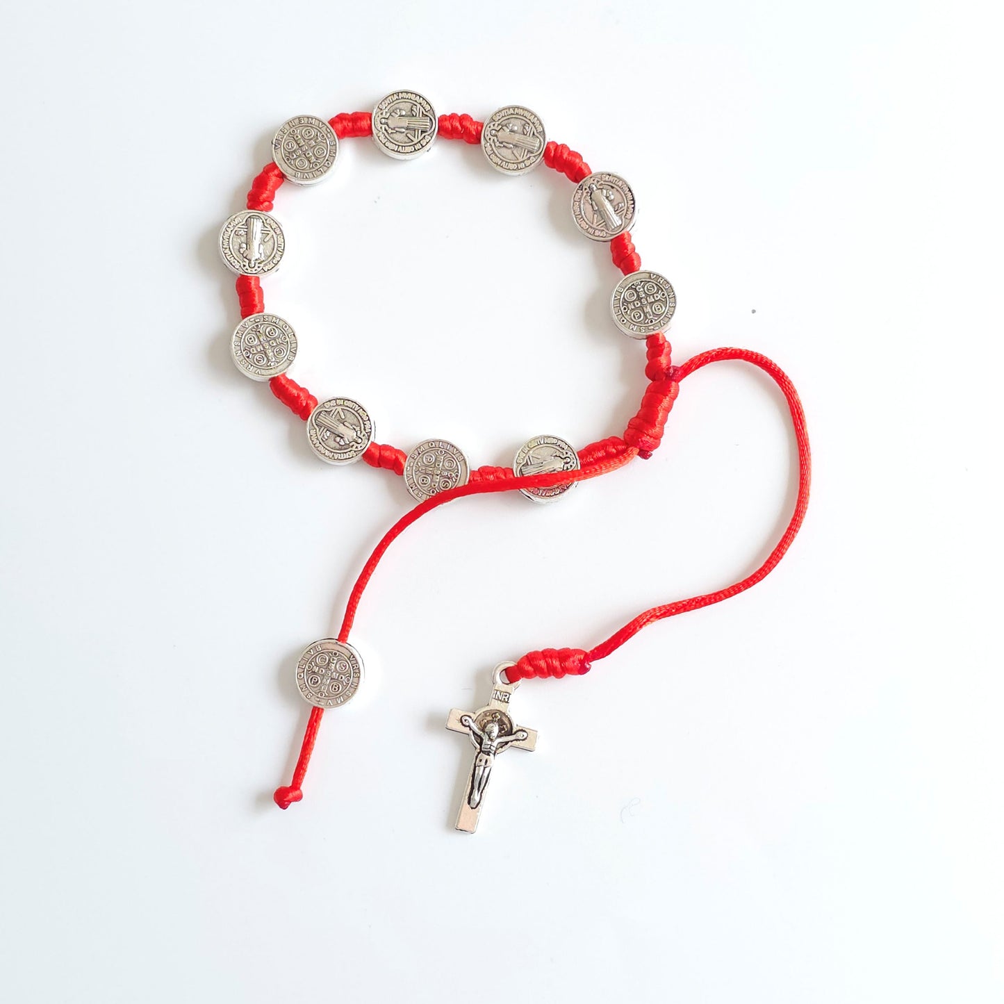 Saint Benedict Adjustable Bracelet with Cross (Red) Red bracelet with silver coin charms on a white background