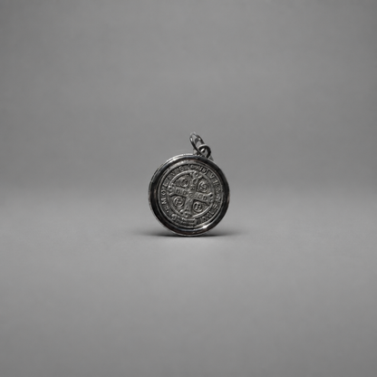 St. Benedict Medal | Pendant + Necklace or Pendant only A round silver pendant with an embossed cross and circular inscription, shown on a neutral gray background.