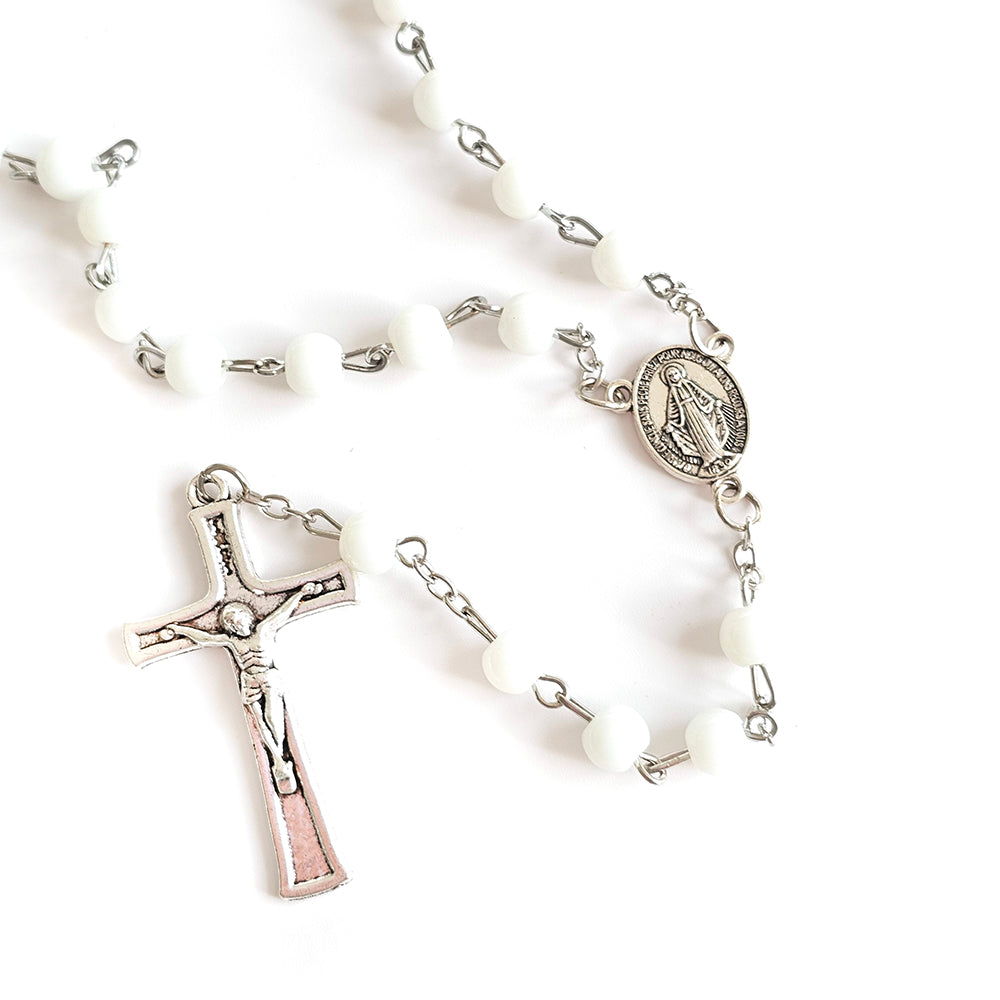 White Bead Catholic Rosary with Silver Crucifix and Virgin Mary Medal White rosary with silver cross and other charms on a white background
