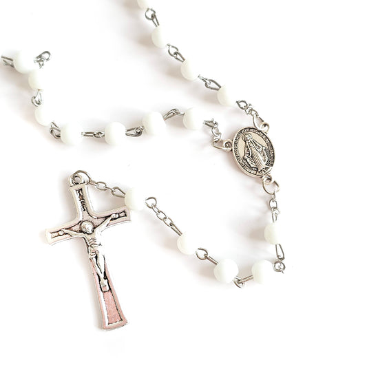 White Bead Catholic Rosary with Silver Crucifix and Virgin Mary Medal White rosary with silver cross and other charms on a white background
